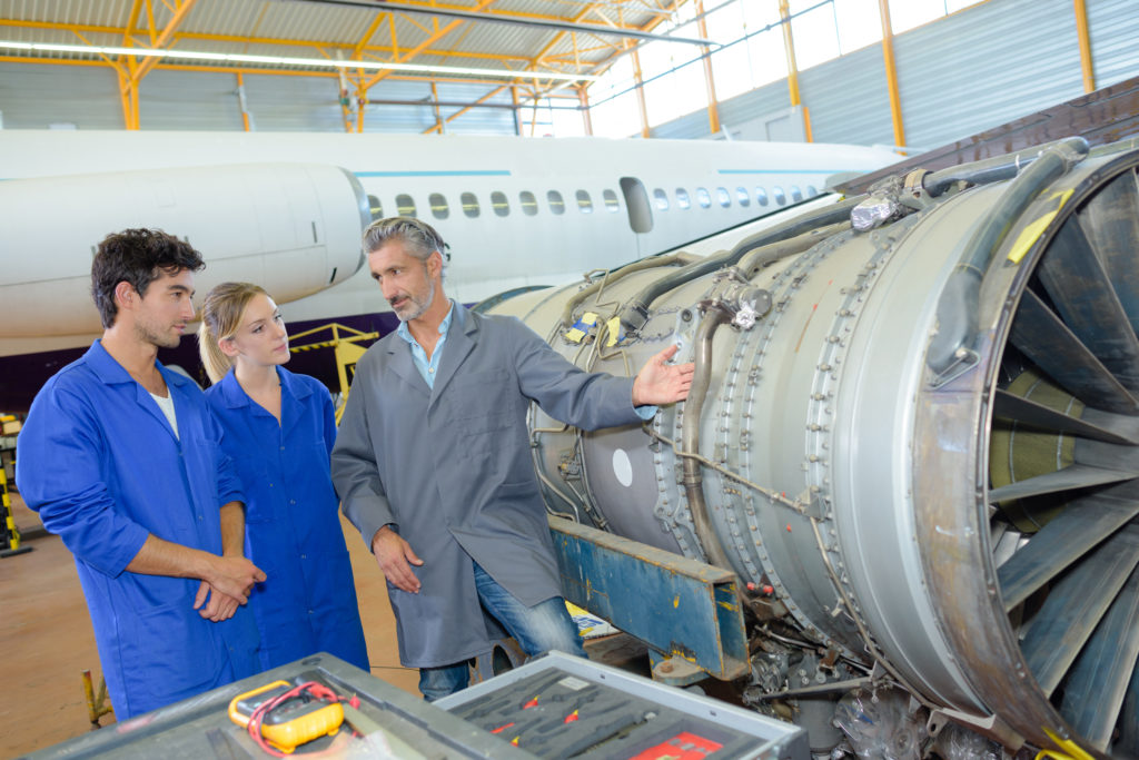 People looking at aircraft engine